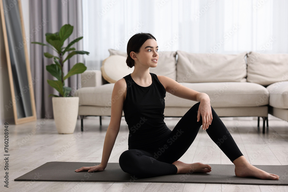 Sticker Beautiful girl sitting on yoga mat at home