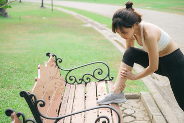 female joggers pain and discomfort after running in the public park. care and treatment for ankle...