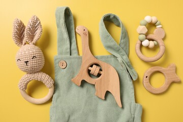 Different baby accessories on yellow background, flat lay