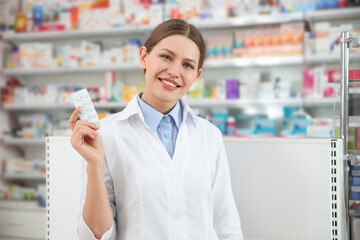 Fototapeta premium Professional pharmacist with pills in modern drugstore