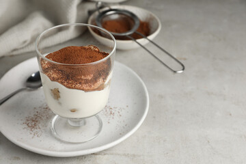 Delicious tiramisu in glass on light table. Space for text