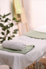 Fototapeta na wymiar Rolled towel on massage table in spa center