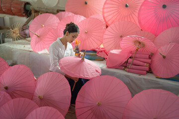 Thai woman people making pink umbrellas. Decoration. People lifestyle
