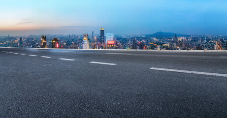 Fototapeta na wymiar Panoramic City Skyline and Open Road at Sunset