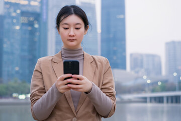 Fototapeta premium Professional Woman Texting on Smartphone in City