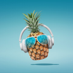 Summer minimalist pop art photography made with pineapple wearing headphones and listening to music.Minimal concept summer and party.Celebrating the summer vibes.Creative art.Contemporary style.