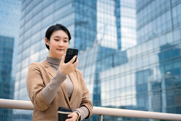 Professional Woman Checking Smartphone in Urban Setting