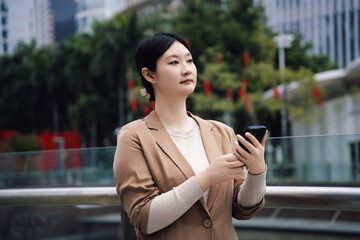 Confident Businesswoman Using Smartphone in Urban Area