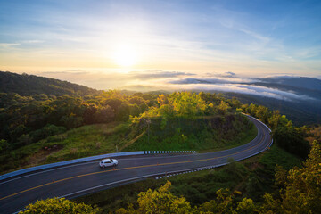 Aerial view of national park Inthanon, cars driving on curved, zigzag curve road or street on mountain hill with green natural forest trees in rural area of Chiang Mai, Thailand. - obrazy, fototapety, plakaty