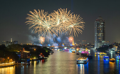 Fireworks at Memorial Bridge, and Phra Pok Klao Bridge with buildings and Chao Phraya River at night. Urban city, Downtown Bangkok, Thailand.