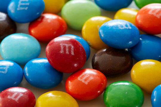 Closeup of colorful M&M candy stacked up in multi and vibrant colors and looking festive