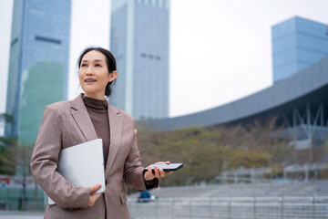 Confident Businesswoman Outdoors With Tablet And Phone