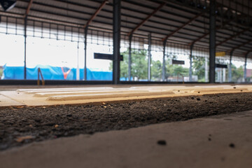 a station floor that uses asphalt with a yellow list as a boundary marker.