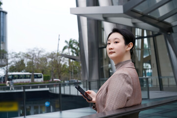 Confident Professional Woman Holding Smartphone Outdoors