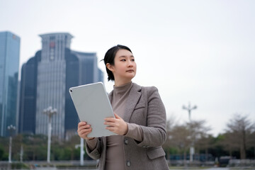 Confident Businesswoman Using Tablet in Urban Setting