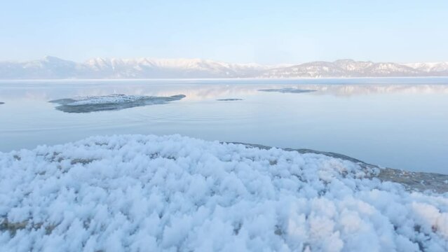 Ripples on calm lake surface in frozen winter landscape, Hokkaido, Japan