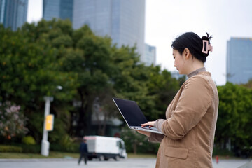 Young Professional Working on Laptop Outdoors