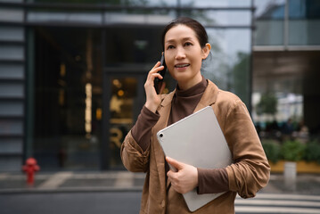 Professional Woman Chatting on Mobile Holding Tablet