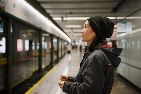 Young Woman Awaiting Train in Subway Station