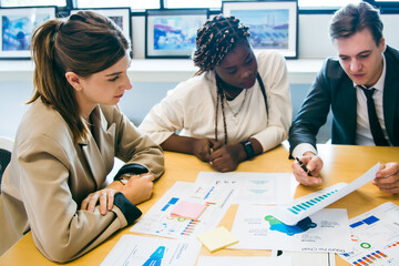 business team meeting with stats and review graphs of company target, goals or market research with data analysis. Above, table or paperwork report of growth, progress or startup performance analytics