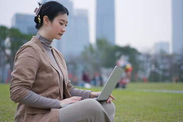 Young Professional Woman Using Laptop in Park