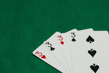 A pile of Poker playing card, playing cards on green background.;