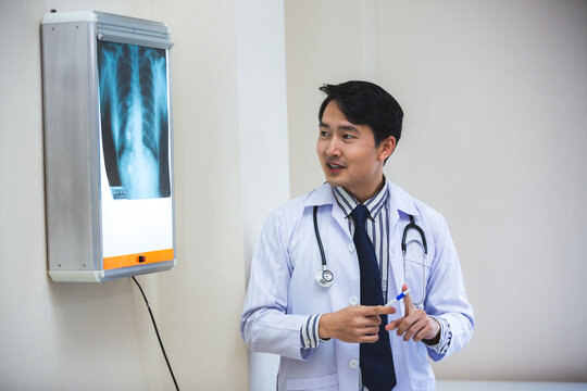 Expertise and professional Male doctor or physician show x-ray film result and explaining, analyzing and diagnosis of health problem, cancer, flu in lung or heart or bone fracture at room in hospital.