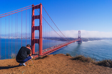 An amateur photographer taking the photo of Golden Gate Bridge.