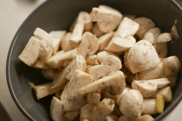 Fresh champignons mushroom in a white bowl on table 
