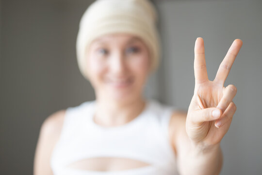 Healthy woman showing 2 finger, V for Victory after overcoming cancer after treatment, concept image of cancer treatment, exercise for self healing, alternative tumor medical treatment
