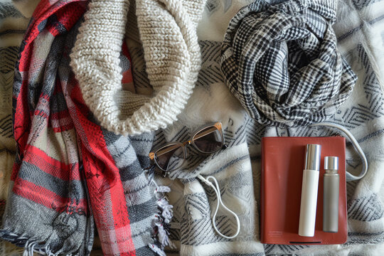 Cozy winter travel essentials on a plaid background.