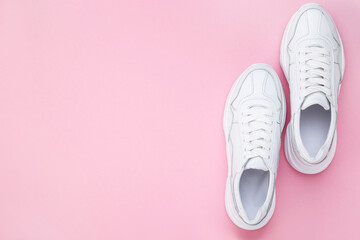 Pair of white shoes on pink background