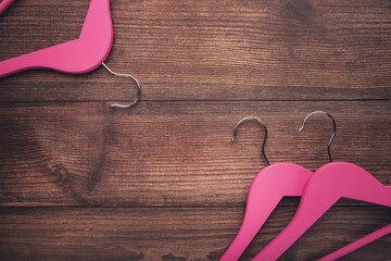 Pink hangers on brown wooden table