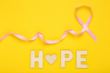 Pink ribbon and inscription Hope on yellow background - 760327568