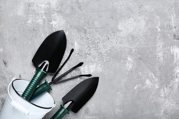 Garden tools and bucket on grey wooden table