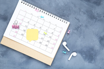 Calendar page with earphones and yellow speech bubble on grey background - 760327765