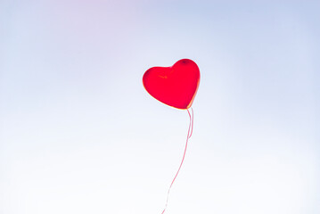 Red heart balloons over blue sky. Love, valentines day, romantic, wadding or birthday background. a...