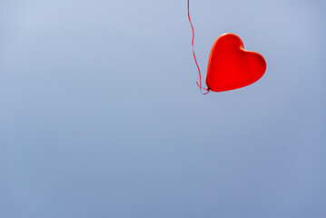 Red heart balloons over blue sky. Love, valentines day, romantic, wadding or birthday background. a...