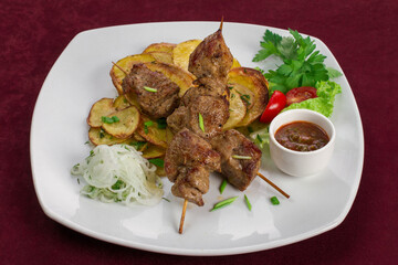 Delicious kebab with fried potatoes on a plate, menu for a restaurant