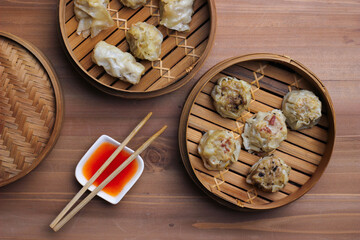 Various Dim Sum in Bamboo Steamed container served with tomato sauce