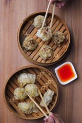Various Dim Sum in Bamboo Steamed container served with tomato sauce