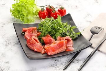 Sliced salmon with fresh arugula