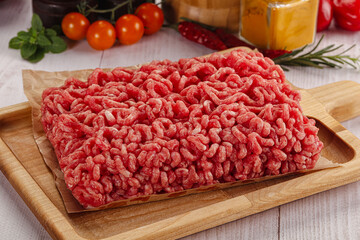 Raw minced beef meat over board