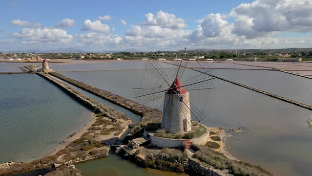 Salt Pans near Marsala at Sicily, Italy in Europe. colorful windmills at the saltpans of Sicily in summer with a blue sky