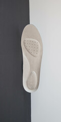Leather orthopedic insole on black white background. Prevention and treatment of flat feet. Foot care.