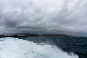 Sea, foam and shore with cloudy sky