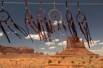 Dream catchers sway gently in the desert breeze, adorning the mystical beauty of Monument Valley's...
