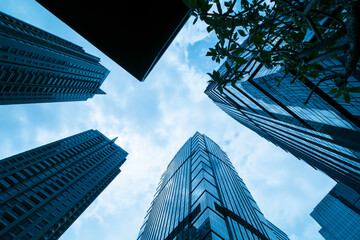 Office tall building. Low angle view of skyscrapers office building in central business district with blue sky - obrazy, fototapety, plakaty