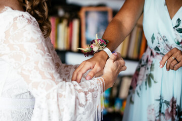 Bride helping Bridesmaid Maid of Honor with a Corsage during Wedding Preparation