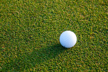 Golf ball on a green lawn in golf course. Sports that people around the world play during the holidays for health.